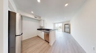 This modern 3-bedroom, 2-bathroom unit in Los Angeles, CA 90016 offers a thoughtfully designed single-floor layout with a clean, contemporary aesthetic throughout. Light wood-tone flooring flows seamlessly across every room, complemented by crisp white walls and recessed lighting that create a bright, airy atmosphere.

The open-concept kitchen and living area serves as the heart of the home. The kitchen features white cabinetry with brushed nickel hardware, dark countertops, stainless steel appliances including a refrigerator, range, built-in microwave, and dishwasher, and a peninsula that opens toward the living space. A sliding glass door in the living room leads to a private balcony with views of the surrounding Los Angeles neighborhood, allowing abundant natural light to fill the space.

The primary bedroom is generously proportioned with a large window framing outdoor views. Additional bedrooms offer comparable finishes, with one room featuring a sliding glass door that opens to an outdoor area. Closet space is provided in the bedrooms. A stacked in-unit washer and dryer is conveniently located within the living area.

Both bathrooms maintain the home's modern palette with white tile, dark countertops, white cabinetry, and tub-shower combinations. A hallway connects the bedrooms and bathrooms, providing a functional and efficient flow throughout the home.