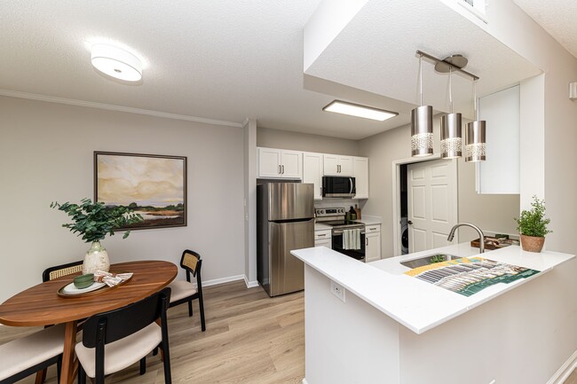 Kitchen with quartz couters, modern cabinetry, & hardwood-style flooring - The Slates at Powdersville