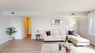 Located at 1712 Waverly Way in Baltimore, MD, this well-appointed 2-bedroom, 1-bathroom single-floor home offers a cohesive, light-filled interior with a modern yet comfortable aesthetic. Light wood-style flooring runs throughout, tying the spaces together seamlessly.

The living room is generously proportioned, featuring a large window that floods the space with natural light and provides views of the surrounding greenery. The adjacent dining area continues this bright theme, with oversized windows and a pass-through window connecting to the kitchen.

The kitchen is thoughtfully designed with white cabinetry, clean white countertops, and a full suite of stainless steel appliances, including a dishwasher, range, and over-the-range microwave. A window above the sink adds additional natural light.

The primary bedroom is a comfortable retreat, offering ample space, a ceiling fan, and a large window. The second bedroom is equally versatile, currently configured as a home office, and features its own ceiling fan, closet, and a bright window with garden views.

The bathroom is clean and functional, finished in white with a tub/shower combination. Hallways connect each room efficiently, contributing to the home's practical, well-organized layout. Overall, the space presents a calm, neutral palette ideal for modern living.
