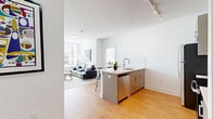 This well-designed 2-bedroom, 2-bathroom residence at 1001 W Elizabeth Ave in Linden, NJ offers a clean, contemporary aesthetic throughout. The open-concept living area seamlessly connects the kitchen, dining, and living spaces, creating an efficient and welcoming environment. Light wood flooring runs throughout the unit, complementing the bright white walls and modern finishes.

The kitchen is a standout feature, equipped with stainless steel appliances including a refrigerator, range, and microwave, paired with taupe shaker-style cabinetry, white quartz countertops, and a subway tile backsplash. A peninsula island with seating provides additional prep space and a casual dining option, illuminated by track lighting above.

Both bedrooms are bright and comfortable, each benefiting from large windows that invite generous natural light and offer outdoor views. The primary bedroom provides a well-proportioned retreat with ample closet space. The unit includes five closets total, ensuring excellent storage throughout.

The two bathrooms feature matching gray vanities with white countertops and wood-look flooring, maintaining the cohesive modern palette. An in-unit laundry room adds everyday convenience. The overall ambiance is bright, clean, and contemporary, making this a practical and stylish residence.