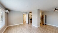 Located at 1163 Hopper Ave in Santa Rosa, CA, this thoughtfully designed one-bedroom, one-bathroom unit offers a clean, modern living experience across a single floor. The open-concept living room and kitchen area is bathed in natural light from large windows with blinds, complemented by recessed lighting and light wood-style luxury vinyl flooring that runs throughout the entire space. A wall-mounted mini-split system provides efficient heating and cooling. The kitchen is well-appointed with white shaker cabinetry extending to the ceiling, light stone countertops, a stainless steel dishwasher, range, and refrigerator, along with a single-basin sink. Neutral gray walls create a calm, cohesive aesthetic throughout. The bedroom is a comfortable, well-proportioned room featuring its own window with natural views, recessed lighting, a mini-split unit, and access to a dedicated closet. The bathroom is clean and functional, offering a full tub-shower combo with built-in shelving, a white vanity with a stone-topped countertop, and matching light wood flooring. The unit's fresh, move-in-ready condition and modern upgrades make it a practical and attractive home in the heart of Santa Rosa.