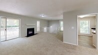 Located in Sandy Springs, GA, this two-story, 2-bedroom, 2-bathroom home offers a well-organized layout across two levels. The main level is anchored by a spacious combined living and dining area featuring plush neutral carpeting, soft grey walls, and a striking fireplace with a classic white mantle. A white-railed staircase adds architectural character, while multiple windows fill the space with natural light. Sliding glass doors open to a private balcony, extending the living area outdoors. The adjacent dining space is highlighted by an elegant chandelier overhead.

The kitchen is well-appointed with white raised-panel cabinetry, dark granite-style countertops, wood-look flooring, and stainless steel appliances including a gas range, dishwasher, and range hood. A large window overlooks lush greenery, bringing in additional natural light.

Both bedrooms are generously sized, carpeted, and finished with neutral tones. The spacious primary bedroom offers ample room for a full furniture suite. Each of the two bathrooms features a tub-shower combo with tile surround, wood-look flooring, and dark countertop vanities. A dedicated closet and hallway complete the thoughtfully designed floor plan of this comfortable Sandy Springs residence.