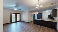 Located in Louisville, KY, this well-appointed 3-bedroom, 2-bathroom single-floor residence offers a functional and cohesive layout designed for comfortable everyday living. The open-concept kitchen and living area serves as the heart of the home, featuring rich dark cabinetry, granite countertops, a peninsula with bar seating, and stainless steel appliances. Wood-style plank flooring runs throughout the main living areas, complemented by an elegant chandelier and ceiling fan. Sliding glass doors in the living room invite natural light and provide outdoor access. The three bedrooms are carpeted for comfort, each equipped with ceiling fans and windows that bring in natural light. The spacious primary bedroom connects to a private en-suite bathroom featuring a glass-enclosed walk-in shower and tile flooring. A second full bathroom includes a soaking tub and shower combo with matching granite vanity. The unit also features five closets for generous storage, a dedicated laundry area, and dark-trimmed interior doors that add a consistent design accent throughout. The neutral color palette and clean finishes create a bright, move-in-ready atmosphere.