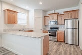 Located in Nampa, Idaho, this two-story home offers a well-organized layout spread across two floors, with the main living areas on the ground floor and bedrooms above. The open-concept living and dining area features light wood-look flooring, a ceiling fan, and multiple windows that invite natural light throughout. The kitchen is equipped with warm wood cabinetry, granite-style countertops, subway tile backsplash, stainless steel appliances including a range and over-the-range microwave, and direct access to a pantry. Upstairs, three bedrooms are carpeted and include ceiling fans and ample natural light. The spacious primary bedroom features a generously sized en-suite bathroom with a dual-sink vanity topped with stone counters, warm wood cabinetry, light wood-look flooring, and a walk-in closet with built-in shelving. A convenient half bath is also available on the main floor. The home includes a dedicated laundry room and an attached two-car garage with an automatic opener. Throughout, five-panel interior doors, neutral tones, and clean finishes contribute to a cohesive and modern aesthetic.