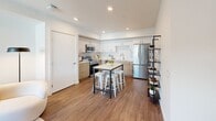 Located at 500 Baker Boulevard in Tukwila, WA, this thoughtfully designed one-bedroom, one-bathroom residence offers a functional and modern layout across a single floor. The open-concept kitchen and living area serves as the heart of the home, featuring wood-look flooring, recessed lighting, and large windows that invite natural light. The kitchen is outfitted with stainless steel appliances, two-tone cabinetry in white and warm wood finishes, a subway tile backsplash, and ample counter space — ideal for everyday cooking and entertaining. The living area is bright and welcoming, with views of the surrounding neighborhood.

The bedroom is a comfortable retreat, complete with a ceiling fan, a large window framing outdoor views, and generous proportions. The clean, white bathroom includes a tub-shower combination and wood-look flooring. Additional highlights include a dedicated office space, two closets for abundant storage, and in-unit laundry. A wide hallway with a sliding barn-door closet connects the rooms seamlessly. The crisp white walls and warm hardwood-style flooring throughout give the space a cohesive, contemporary feel that is both practical and inviting.