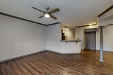 Located at 701 Highland Ave NE in Atlanta's vibrant Old Fourth Ward neighborhood, this one-bedroom, one-bathroom unit offers a well-designed, single-story layout. The open-concept living and kitchen area serves as the heart of the home, featuring rich hardwood-style flooring, crown molding with dark accents, and a ceiling fan that enhances the airy feel. A decorative column adds architectural character to the space. Natural light flows in through multiple windows and a glass-panel door in the living room.

The kitchen is equipped with dark espresso cabinetry, stainless steel appliances including a range, microwave, and refrigerator, and granite-style countertops that extend to a breakfast bar with an undermount sink — ideal for casual dining or meal prep. Track lighting overhead keeps the space bright and functional.

The bedroom features plush carpeting, a sun-filled window, and access to a generously sized walk-in closet with wire shelving on multiple walls. The full bathroom includes a granite-topped vanity, tiled tub-shower combo with a decorative accent tile border, and tile flooring. A dedicated laundry room with a full-size washer and dryer completes the unit's practical offerings.