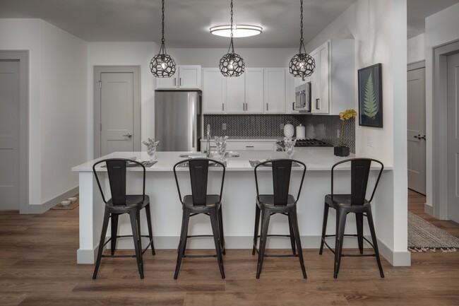 Kitchens include stainless appliances and tile backsplash - Mill District Apartments