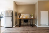 Located at 1425 Block Line Rd in Kitchener, Ontario, this thoughtfully designed one-bedroom, one-bathroom unit offers a comfortable and modern living experience across a single floor. The open-concept layout connects the kitchen and living area seamlessly, creating an efficient and welcoming atmosphere throughout.

The kitchen features a sleek white peninsula with an integrated sink, modern white cabinetry, light hardwood-style flooring, and stainless steel appliances including a full-size refrigerator and dishwasher. Large black-framed windows flood the space with natural light and provide views of the surrounding urban landscape.

The living room is bright and airy, with warm neutral-toned walls and the same hardwood-style flooring continuing throughout. A floor-to-ceiling sliding glass patio door opens to an outdoor area, further enhancing the sense of openness and bringing in abundant light.

The bedroom is a well-proportioned retreat featuring dual large windows with roller shades, warm hardwood-style flooring, and a spacious sliding-door closet with built-in shelving — providing ample storage.

The bathroom is clean and functional, offering a full soaker tub with a shower curtain, a white vanity with undermount sink, tile flooring, and a large mirror. Warm, neutral tones carry throughout, giving the entire unit a cohesive and contemporary aesthetic.