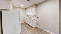 Located at 11300 Mesa Dr in Little Rock, Arkansas, this 2-bedroom, 1-bathroom single-floor home offers a well-organized layout with consistent design elements throughout. Wood-look plank flooring runs through every room, creating a cohesive and easy-to-maintain aesthetic. Each room is equipped with a ceiling fan with light kit, adding both comfort and practical overhead lighting.

The living area features crown molding, a textured ceiling, and a sliding glass door that opens to a balcony, allowing natural light to fill the space. The kitchen is outfitted with white cabinetry, granite-look countertops, a tile backsplash, a stainless steel sink, and white appliances including a refrigerator and dishwasher. A set of double doors within the kitchen provides access to additional storage or utility space.

The primary bedroom is generously proportioned, offering ample room for furnishings, and includes a ceiling fan and a large double-door closet. The second bedroom similarly features a ceiling fan and a window that brings in natural light. The bathroom is well-appointed with white cabinetry, granite-look countertops, a single-sink vanity, and a full tub-shower combination accented by warm-toned large-format tile surround.