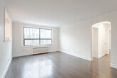 Located at 110 South Forster Park in Oakville, Ontario, this 2-bedroom, 1-bathroom unit offers a well-organized layout across a single floor. The combined living and dining area is bright and airy, featuring hardwood flooring, clean white walls, crown moulding, and large black-framed windows that frame treetop views and fill the space with natural light. A radiator beneath the windows provides classic in-unit heating. An elegant arched passageway connects the living area to the hallway, adding a touch of architectural character.

The kitchen is efficiently designed with white cabinetry, a double-basin sink, and a window overlooking the surrounding greenery. A pass-through window opens to the dining area, enhancing the sense of connectivity between the kitchen and living spaces. The unit's tile flooring in the kitchen provides a practical contrast to the hardwood found throughout the rest of the home.

Both bedrooms are comfortably proportioned, with hardwood floors and windows offering wooded outdoor views. The primary bedroom features two closets, providing ample storage. The bathroom is clean and functional, finished with neutral tile flooring, a white vanity, and a combined tub-shower unit. This unit presents a tidy, move-in-ready space in a natural Oakville setting.