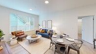 Located in Sumner, WA, this well-designed 2-bedroom, 2-bathroom residence offers a thoughtful single-floor layout with modern finishes throughout. Light wood-tone flooring flows seamlessly across all rooms, creating a cohesive and airy feel.

The kitchen is a standout feature, showcasing two-tone cabinetry with dark wood lower cabinets and crisp white uppers, stainless steel appliances including a refrigerator, range, and over-the-range microwave, and clean white countertops. A hallway connects the kitchen to the rest of the unit, with in-unit stacked washer and dryer conveniently tucked into a closet.

The living room benefits from a large window that invites natural light and offers views of the surrounding greenery, creating a bright and welcoming atmosphere. The space comfortably accommodates both a seating area and a dining table.

Both bedrooms are well-proportioned, with the primary bedroom featuring a dedicated window and closet with built-in shelving. The two bathrooms offer modern vanities with dark wood cabinetry and white countertops, with one featuring a bathtub. Recessed lighting throughout the unit adds to the clean, contemporary aesthetic of this efficiently designed home.
