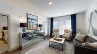 Located in the heart of Kansas City's River Market neighborhood, this well-appointed single-floor residence offers a thoughtfully designed layout with modern finishes throughout. The open-concept living area is bright and welcoming, featuring wood-style flooring, large windows dressed with blinds and elegant draping, and ample space for comfortable seating arrangements. A mirrored credenza and bold abstract artwork add a sophisticated, contemporary touch to the living space.

The kitchen is a standout feature, boasting white shaker cabinetry, dark quartz countertops, a subway tile backsplash, and a full suite of stainless steel appliances including a refrigerator, range, and built-in microwave. A peninsula with bar seating and pendant lighting overhead makes the kitchen ideal for both casual dining and entertaining. An in-unit laundry area is conveniently accessible from the kitchen.

Both bedrooms are generously sized with plush carpeting, ceiling fans, and windows that allow for natural light. The primary bedroom provides ample space for a full furniture arrangement. The bathrooms are finished with dark quartz vanity tops, white cabinetry, wood-look flooring, and white subway tile — one featuring a glass-enclosed shower and the other a full tub-shower combination with built-in shelving nearby.