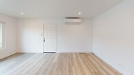 Located at 399 Erbes Rd in Thousand Oaks, CA, this single-floor, 3-bedroom, 1-bathroom unit offers a thoughtfully updated interior with a clean, modern aesthetic. Light wood-style flooring runs consistently throughout the space, complementing the crisp white walls and creating a bright, cohesive feel.

The living room provides an open, welcoming entry point, featuring a wall-mounted mini-split HVAC unit for climate control and recessed lighting overhead. The kitchen is well-appointed with white shaker cabinetry extending to the ceiling, stainless steel appliances including a refrigerator, range, and dishwasher, a single-basin sink, and white countertops — all finished with matte black hardware for a contemporary touch. A separate pantry adds valuable storage.

Each of the three bedrooms is finished with the same light flooring and white walls, offering a neutral canvas. Two of the bedrooms feature ceiling fans and windows that bring in natural light and neighborhood views. The primary bedroom provides a generous footprint among the three.

The bathroom is neatly designed with a subway tile tub-shower surround, matte black fixtures, a white vanity with cabinet storage, and wood-look flooring. Four closets are distributed throughout the unit, and a hallway connects the rooms efficiently. The overall ambiance is clean, modern, and move-in ready.