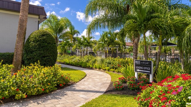 Stroll through the vibrant and lushly landscaped walkway leading to the leasing office. Surrounded by tropical plants and greenery, this inviting path sets the tone for a welcoming and serene community. - POSTE Winter Park