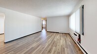 Located at 124 Capitol View Terr in Madison, WI, this 2-bedroom, 1-bathroom unit offers a clean, efficiently designed single-floor layout. Consistent hardwood-style flooring runs throughout all rooms, complemented by crisp white walls and bold black door trim that create a modern, cohesive aesthetic. Textured ceilings are found in several areas, adding visual character overhead.

The spacious living room is a standout area, featuring a large window with vertical blinds that allows ample natural light, a baseboard heating system, and a wall-mounted air conditioning unit for year-round comfort. The kitchen is well-appointed with white shaker-style cabinetry, dark stone countertops, a stainless steel electric range, an under-cabinet range hood, and a double sink — all illuminated by overhead fluorescent lighting.

The primary bedroom offers a generous footprint, featuring a double-panel closet with bold black trim framing, hardwood-style floors, and natural light. The second bedroom also includes a window with exterior views, baseboard heating, and a textured ceiling. The full bathroom is finished with a white vanity, under-sink storage, a combined tub and shower, and backlit mirror — all in a clean, bright white palette.