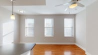 Located at 1351 Walnut St in the heart of Cincinnati, OH, this two-floor residence offers a well-designed layout with a blend of practical finishes and comfortable living spaces throughout.

The main living area features warm hardwood flooring and is bathed in natural light through a trio of double-hung windows fitted with blinds. A ceiling fan with integrated lighting adds both comfort and functionality to the space. Adjacent to the living area, the kitchen is a functional highlight, equipped with warm wood cabinetry, granite-style countertops, black appliances including a refrigerator, range, and microwave, as well as a double-basin sink. A peninsula with pendant lighting above provides additional prep space and a casual dining option, while recessed lighting and hardwood flooring complete the kitchen's clean, modern aesthetic.

The bathrooms feature tile flooring, warm wood vanities with dark countertops, large mirrors, and chrome fixtures, offering a consistent and polished finish. The bedrooms are carpeted for comfort and include sliding-door closets with built-in shelving and hanging rods. One bedroom benefits from elevated ceilings and a window with an exterior view, enhancing the sense of openness. A staircase connects the two floors, and the overall neutral color palette throughout creates a cohesive, move-in-ready environment.