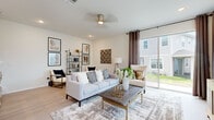 Located at 1244 Eagle Branch Ln in Davenport, Florida, this two-story home offers a well-designed layout with modern finishes throughout. The open-concept main floor centers around a striking kitchen, featuring crisp white shaker cabinetry, quartz countertops, a large center island, a breakfast bar with seating, stainless steel appliances including a French door refrigerator, and elegant pendant lighting. Light wood-style flooring flows seamlessly throughout the main level, enhancing the bright, airy atmosphere. Adjacent to the kitchen is a dedicated dining area with a large window that fills the room with natural light, and a comfortable living room with sliding glass doors that open to outdoor views. The living room is generously proportioned, offering ample space for relaxation. A powder room on the main floor provides added convenience for guests. Upstairs, the primary bedroom is a serene retreat highlighted by a tray ceiling, striped accent wall, and large windows with natural light. Additional bedrooms include a warmly decorated room with soft accent tones and a third bedroom with angled ceilings and a playful character. Each room features light flooring and ceiling fans. The home's cohesive design, neutral palette, and modern touches make it a functional and stylish residence.