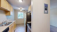Located at 7501 Greenfield Ave in Mounds View, MN, this single-floor, one-bedroom, one-bathroom unit offers a practical and well-organized layout. The galley-style kitchen is lined with warm honey-toned wood cabinetry — both upper and lower — providing ample storage space. It is equipped with stainless steel appliances, including a refrigerator and dishwasher, and features a double basin sink with light-toned countertops. Tile flooring runs throughout the kitchen, adding durability and easy maintenance. Adjacent to the kitchen, a secondary area with a ceiling fan and a window offers natural light and additional flexibility. The bedroom is comfortably sized, featuring plush wall-to-wall carpeting, a ceiling fan, a large sliding-door closet, and a window overlooking the surrounding greenery. The full bathroom includes mosaic tile flooring, large-format wall tiles surrounding a soaking tub and shower, a single-sink vanity with wood cabinetry, and a mirrored medicine cabinet. Neutral tones and consistent finishes throughout the unit create a clean, cohesive aesthetic. Baseboard heating is present in multiple rooms, ensuring comfort during Minnesota winters.