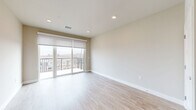 Located at 430 S Yellowstone Dr in Madison, WI, this well-appointed one-bedroom, one-bathroom unit offers a thoughtfully designed open-concept layout with clean, contemporary finishes throughout. The combined kitchen and living area serves as the heart of the home, anchored by a sleek peninsula with a white quartz countertop, an undermount sink, and stylish pendant lighting. Warm wood-toned cabinetry lines the galley-style kitchen, which is fully equipped with stainless steel appliances including a range, microwave, dishwasher, and refrigerator. Light hardwood-style flooring runs throughout the main living areas, enhancing the bright, airy ambiance. The living room opens directly onto a private balcony through full-height sliding glass doors, flooding the space with natural light and providing outdoor views. The bedroom is a comfortable retreat featuring plush carpet, a ceiling fan, and a window with a roller shade. A dedicated closet provides convenient storage. The bathroom maintains the same cohesive design language with wood-toned cabinetry, a white countertop vanity, and wood-look tile flooring. Recessed lighting and neutral wall tones tie the entire unit together in a clean, modern aesthetic.