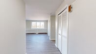 This 1070 square foot apartment, located at 107 Grand Ave in London, Ontario, offers a harmonious blend of space and modern design. The single-floor layout encompasses three bedrooms, a living room, kitchen, and closet space, providing ample room for comfortable living.

The property boasts a contemporary aesthetic with neutral-toned walls and sleek laminate flooring throughout. Large windows in multiple rooms flood the space with natural light and offer picturesque views of the city skyline and surrounding landscape. The primary bedroom, measuring 160 square feet, ensures a spacious retreat.

The living area is particularly noteworthy, featuring expansive windows and French doors that lead to an outdoor space, perfect for enjoying fresh air or urban views. Efficient heating is provided by stylish radiator covers beneath the windows.

The kitchen is equipped with modern appliances, including a stainless steel refrigerator and range, complemented by crisp white cabinetry. This combination of functionality and style extends throughout the apartment, with thoughtful details like recessed lighting and clean architectural lines.

An unexpected highlight is the outdoor balcony, which provides a private space to enjoy the open air and overlook the leafy surroundings. This feature adds a valuable extension to the living space, enhancing the overall appeal of this urban dwelling.