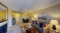 Located at 8330 E Quincy Ave in Denver, Colorado, this single-floor residence offers a thoughtfully designed layout with a seamless flow between living spaces. The open-concept living and dining area is carpeted throughout, with warm neutral-toned walls and a textured ceiling that add character to the room. The living area accommodates generous seating and features a sliding glass door that opens onto a private balcony, filling the space with natural light and providing pleasant outdoor views of surrounding greenery. The dining area is positioned adjacent to the living room, creating an ideal setup for both everyday living and entertaining. The galley-style kitchen features rich dark wood cabinetry, light countertops, wood-look flooring, and black appliances including a refrigerator, range, and built-in microwave, offering ample storage and functional workspace. The bedroom is carpeted and well-proportioned, with a sliding glass door allowing natural light to enter, and includes access to a walk-in closet for generous storage. The bathroom is outfitted with warm wood vanity cabinetry, a wide countertop, a large mirror, and bright overhead lighting, creating a clean and functional space. Overall, the residence presents a comfortable and practical living environment in a convenient Denver location.