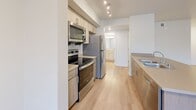Located in Lynnwood, Washington, this 2-bedroom, 3-bathroom residence offers a thoughtfully designed single-floor layout that maximizes both comfort and functionality. The open-concept living, dining, and kitchen area forms the heart of the home, featuring light wood-look flooring, crisp white walls, and a wall-mounted mini-split system for year-round climate control. The kitchen is well-appointed with stainless steel appliances — including a refrigerator, electric range, and over-the-range microwave — complemented by light wood cabinetry, neutral countertops, and a peninsula island with a built-in sink, ideal for casual dining or meal prep. The living area receives natural light through windows and opens to a private balcony. Both bedrooms are carpeted and include ceiling fans and dedicated closets with built-in shelving, while the spacious primary bedroom features a walk-in closet. Three full bathrooms each include tub/shower combinations and are finished with light wood flooring and clean, neutral fixtures. Additional highlights include three closets for ample storage, a dedicated laundry area, and a hallway connecting all spaces. The overall aesthetic is modern and move-in ready, with a clean, neutral palette throughout.