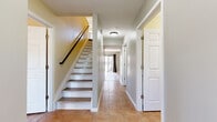 Located at 680 E Buchtel Ave in Akron, Ohio, this two-story home offers five bedrooms and five bathrooms across two well-proportioned floors. The main level greets you with a tiled entryway hallway leading to a bright, open living room featuring wide-plank hardwood-style flooring and large sliding glass doors that flood the space with natural light and provide outdoor views. The kitchen is outfitted with sleek grey cabinetry, dark countertops with a black tile backsplash, marble-look tile flooring, and stainless steel appliances. A dedicated laundry room with a full-size washer and dryer adds everyday convenience. The upper floor houses the majority of the bedrooms, each featuring hardwood-style flooring, neutral tones, and generous closet space — including walk-in and double-door closet configurations with built-in shelving. The five bathrooms are thoughtfully finished with modern vanities featuring grey wood-tone cabinetry, granite-style countertops, and striking marble-look tile flooring. A classic staircase with a dark handrail and white risers connects both levels. With four closets distributed throughout, the home provides practical storage solutions to complement its clean, contemporary aesthetic.