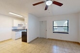 Located at 889 Riverside Dr in Fort Lauderdale, FL, this single-floor, one-bedroom, one-bathroom unit offers a practical and comfortable layout. The combined living and dining area features light-toned ceramic tile flooring, a ceiling fan with integrated lighting, and a window that invites natural light while offering a view of the surrounding greenery. The space flows directly into the kitchen, which is efficiently designed with white shaker-style cabinetry, granite countertops, a stainless steel sink, and black appliances including a refrigerator and electric range with an overhead exhaust. A dedicated window in the kitchen adds additional natural light and ventilation. The bedroom is a generously proportioned retreat finished with plush carpeting, a textured ceiling, and a window that fills the room with soft, natural light. It provides direct access to the full bathroom and features a dedicated walk-in closet, with additional closet storage also available. The bathroom is finished with warm-toned ceramic tile surrounding a full soaking tub and shower combination, accented by chrome fixtures. Throughout the unit, three closets offer exceptional storage capacity. The clean, neutral palette and tile and carpet flooring combination create a bright, easy-to-maintain living environment.