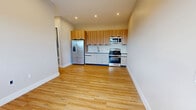 Located at 58 Hamilton Avenue in Passaic, NJ, this thoughtfully designed 3-bedroom, 2-bathroom unit offers a clean, modern aesthetic throughout its single-floor layout. Warm hardwood-style flooring flows seamlessly through every room, complemented by neutral wall tones and crisp white trim that create a bright, cohesive atmosphere.

The open-concept kitchen and living/dining area serves as the heart of the home. The kitchen is outfitted with stainless steel appliances — including a gas range, over-the-range microwave, and French door refrigerator — paired with two-tone cabinetry featuring wood-finish upper cabinets and white lower cabinets, accented by a subway tile backsplash.

Three well-proportioned bedrooms each feature large windows that invite abundant natural light and offer views of the surrounding Passaic neighborhood. Individual PTAC wall units provide heating and cooling in each bedroom. The primary bedroom includes direct access to a private en-suite bathroom, while ample closet space is distributed throughout the unit.

The two bathrooms are finished with stylish tilework, including a full bathroom featuring a glass-enclosed tub and shower combination with patterned tile accents. Additional conveniences include a dedicated laundry area and a hallway connecting all spaces efficiently.