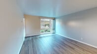 Located at 3750 Tamayo St in Fremont, California, this single-floor residence offers a well-organized layout with a clean, neutral aesthetic throughout. The living area is bright and inviting, featuring light-toned wood-look flooring, soft wall colors, and a large sliding glass door paired with windows that frame views of the surrounding greenery, filling the room with natural light.

The kitchen is designed with functionality in mind, featuring a pass-through counter that opens to the adjacent living and dining area, white cabinetry, a built-in cooktop, and a full-size refrigerator. A ceiling-mounted light fixture adds a warm, focused glow to the space. A hallway connects the kitchen to the rest of the home.

The bedroom is carpeted for comfort and includes a sliding glass door that opens directly to a private outdoor patio area, offering a seamless connection between indoor and outdoor living. The warm, neutral wall tones contribute to a calm and restful atmosphere.

The bathroom is neatly appointed with a tub-shower combination, a vanity with white cabinetry and a wide mirror with overhead lighting, and wood-look flooring that ties in with the rest of the home. A frosted window provides natural light while maintaining privacy.

Overall, this residence presents a cohesive and move-in-ready interior with consistent finishes and convenient access to outdoor spaces throughout.