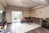 Located at 309 Springfield Ave in Hudson, Iowa, this well-appointed two-bedroom, two-bathroom residence offers a thoughtfully designed single-floor layout. The open-concept living and kitchen area serves as the heart of the home, where the living room features a tray ceiling with track lighting, warm neutral walls, and wood-style flooring. A sliding glass door opens to a private balcony with outdoor seating, allowing natural light to fill the space and providing pleasant views of surrounding greenery. The kitchen is equipped with dark espresso cabinetry, stainless steel appliances including a range, microwave, dishwasher, and refrigerator, complemented by light countertops and additional track lighting overhead. The spacious primary bedroom offers a large closet and a window overlooking the outdoors, while the second bedroom provides a comfortable, well-lit retreat. Both bathrooms feature shower/tub combinations and wood-style flooring. The residence also includes four closets for ample storage, a dedicated laundry area, a utility room, and a hallway connecting all spaces efficiently. The consistent flooring, neutral color palette, and practical layout create a cohesive and functional living environment throughout.