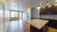 Located at 1772 Steel St in Louisville, Colorado, this single-floor residence offers a thoughtfully designed open-concept layout with a seamless flow between the kitchen, dining, and living areas. Rich hardwood flooring runs throughout the main living spaces, creating a warm and cohesive aesthetic.

The kitchen is a standout feature, showcasing dark espresso cabinetry that extends to the ceiling, granite countertops, a classic subway tile backsplash, and a center island with pendant lighting above. Stainless steel and black appliances — including a refrigerator, range, built-in microwave, and dishwasher — complete the well-equipped cooking space. Track lighting adds both function and style overhead.

The living area is bright and welcoming, benefiting from natural light through multiple windows and a glass-panel door that opens to an outdoor space. The bedroom is carpeted for comfort and features a window with natural light. The bathroom is finished with tile flooring, a soaking tub, granite-topped vanity, and dark wood cabinetry — consistent with the home's design language throughout. A dedicated laundry closet with a stacked washer and dryer is conveniently accessible from the bathroom. The entryway provides a clean, practical transition into the home.