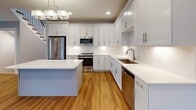 Located at 111 Locust St in Woburn, MA, this three-floor home offers a thoughtfully designed layout with contemporary finishes throughout. The main living area features warm hardwood flooring, soft neutral wall tones, recessed lighting, and large windows that allow ample natural light to fill the space. A door provides convenient access to the outdoors, enhancing the open, airy feel of the room.

The kitchen is a standout feature, showcasing white shaker-style cabinetry extending to the ceiling, light quartz countertops, a subway tile backsplash, and a central island. Stainless steel appliances—including a refrigerator, range, built-in microwave, and dishwasher—complete this functional and elegant space. Pendant lighting and hardwood floors add warmth and character.

The bathrooms are finished with white vanities, marble-style countertops, brushed gold or nickel hardware, and clean tile flooring. One bathroom includes accessibility grab bars, reflecting thoughtful, inclusive design. A bright half-bath with a window-mounted vanity offers additional convenience.

Upper-level bedrooms are carpeted and bathed in natural light from multiple windows with neighborhood views. Generous walk-in closet space with wire shelving provides ample storage.

The unfinished basement level offers substantial open space with visible mechanicals and utility infrastructure, presenting excellent potential for future customization or storage use.