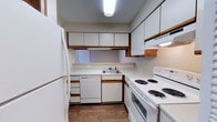 Located at 450 Johnny Mercer Blvd in Savannah, Georgia, this single-floor space offers a practical and well-organized layout. The kitchen is a standout feature, designed in a U-shaped configuration that maximizes efficiency and workspace. It is outfitted with white cabinetry accented by warm wood trim, providing generous storage both above and below the countertops. The light-toned countertops offer ample prep space, complemented by a stainless steel sink positioned beneath upper cabinets. A full suite of white appliances is included, featuring a refrigerator, dishwasher, electric coil range with oven, and an over-the-range ventilation hood. Overhead fluorescent lighting ensures the kitchen is well-lit throughout. The flooring is finished in hardwood-style planking, adding warmth and a cohesive aesthetic to the space. The overall design prioritizes function and practicality, making it well-suited for everyday use. Situated in the Wilmington Island area of Savannah, the property benefits from a convenient coastal Georgia location near local amenities, waterways, and the charm that defines the greater Savannah region.