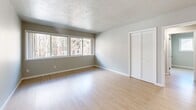 Located at 295 3rd St in Lake Oswego, Oregon, this 2-bedroom, 1-bathroom residence offers a practical and well-organized single-floor layout. Light-toned laminate flooring runs consistently throughout the space, creating a clean, cohesive aesthetic. Neutral gray walls and white trim contribute to a bright, airy atmosphere across all rooms.

The primary bedroom is a comfortable size, featuring a large multi-pane window that invites natural light and offers views of the surrounding tree-lined neighborhood. A louvered bifold closet door provides ample storage. The second bedroom mirrors this layout with its own closet and ceiling fan with integrated lighting, adding functional comfort to both rooms.

The galley-style kitchen is efficiently designed with warm-toned wood cabinetry, light quartz-style countertops, a stainless steel refrigerator, dishwasher, and a single-basin sink — offering a fully equipped cooking space. The full bathroom includes a tiled tub-shower combination, a single-sink vanity with wood cabinetry, and laminate flooring.

A connecting hallway ties the rooms together, while a textured ceiling in select areas adds subtle architectural character. Ceiling fans in each bedroom provide year-round climate control, complementing the wall-mounted heating vents throughout.