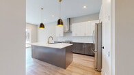 Located at 601 Press Pl in Nashville, Tennessee, this thoughtfully designed one-bedroom, one-bathroom residence offers an efficient and stylish single-floor layout. Light-toned hardwood flooring flows throughout, creating a warm and cohesive aesthetic.

The kitchen is a standout feature, showcasing two-tone cabinetry with crisp white upper cabinets and slate-gray lower cabinets, all accented with brushed gold hardware. A large center island with a white quartz countertop and a gold-finish faucet serves as the focal point, illuminated by striking black-and-gold pendant lights. A herringbone tile backsplash, stainless steel appliances including a range and refrigerator, and a wall-mounted range hood complete this designer space.

The bedroom is bright and airy, with soft gray walls, white trim, and two windows that invite natural light and views of greenery outside. The space feels calm and well-proportioned, with clean lines throughout.

The bathroom features large-format marble-look tile flooring, a wood-toned vanity with ample drawer storage, a white countertop, a backlit mirror, and matte black hardware and fixtures, offering a spa-like atmosphere. A dedicated closet provides practical storage. This residence combines modern finishes with functional design in the heart of Nashville.