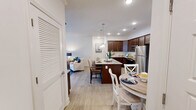 Located at 2411 Wave Rock Way in Knoxville, Tennessee, this single-floor, 2-bedroom, 2-bathroom residence offers a thoughtfully designed layout with a warm and inviting ambiance throughout. The open kitchen is a standout feature, showcasing rich dark-wood cabinetry, granite countertops, a herringbone tile backsplash, and stainless steel appliances, including a range, microwave, and refrigerator — ideal for everyday cooking and entertaining. The adjacent living room is bright and welcoming, with light hardwood flooring, a ceiling fan, crown molding, and natural light streaming through large windows dressed with decorative curtains. Both bedrooms are comfortably sized, with soft carpeting and ample natural light. The primary bedroom offers a cozy retreat, while the second bedroom features large windows and neutral tones. Each bedroom is served by its own closet with wire shelving systems for organized storage. The two bathrooms include a tub-shower combination with a framed glass enclosure and a separate full bath with a tub and shower curtain, both finished with light tile flooring. A dedicated laundry room with wire shelving adds everyday convenience. This residence provides a functional and comfortable living experience in a well-maintained setting.
