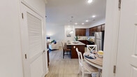 Located at 2411 Wave Rock Way in Knoxville, Tennessee, this single-floor, 2-bedroom, 2-bathroom residence offers a thoughtfully designed layout with a warm and inviting ambiance throughout. The open kitchen is a standout feature, showcasing rich dark-wood cabinetry, granite countertops, a herringbone tile backsplash, and stainless steel appliances, including a range, microwave, and refrigerator — ideal for everyday cooking and entertaining. The adjacent living room is bright and welcoming, with light hardwood flooring, a ceiling fan, crown molding, and natural light streaming through large windows dressed with decorative curtains. Both bedrooms are comfortably sized, with soft carpeting and ample natural light. The primary bedroom offers a cozy retreat, while the second bedroom features large windows and neutral tones. Each bedroom is served by its own closet with wire shelving systems for organized storage. The two bathrooms include a tub-shower combination with a framed glass enclosure and a separate full bath with a tub and shower curtain, both finished with light tile flooring. A dedicated laundry room with wire shelving adds everyday convenience. This residence provides a functional and comfortable living experience in a well-maintained setting.