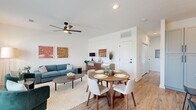 This thoughtfully designed 2-bedroom, 2-bathroom single-story home offers a functional and stylish open-concept layout. The combined living and dining area is bright and welcoming, featuring warm wood-look flooring, crisp white walls, and a modern ceiling fan. Large windows in the living area invite abundant natural light and views of the surrounding neighborhood, creating an airy atmosphere ideal for both relaxing and entertaining.

The kitchen is a standout feature, boasting gray shaker-style cabinetry, white countertops, a classic subway tile backsplash, and stainless steel appliances. A central island with seating provides additional prep space and serves as a natural gathering point, illuminated by elegant globe pendant lights.

The primary bedroom offers a comfortable retreat with a sliding-door closet, wood-look flooring, and clean white walls. The second bedroom is equally well-proportioned, with its own closet and access to a full bathroom. Both bathrooms are finished with gray cabinetry, white countertops, and wood-look flooring. The primary bathroom features a glass-enclosed shower, while the second bathroom includes a tub-shower combination with marble-style tile surround and matte black fixtures throughout. The home's cohesive design elements create a modern yet inviting aesthetic from room to room.