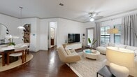 Located at Sanctuary Approach Road in Orlando, FL, this well-appointed 2-bedroom, 2-bathroom residence offers a thoughtfully designed single-level layout that maximizes comfort and functionality. The open-concept living, dining, and kitchen area serves as the heart of the home, featuring rich dark hardwood-style flooring, crown molding, and ceiling fans throughout. Large windows invite abundant natural light, creating a bright and welcoming ambiance. The kitchen is equipped with dark espresso cabinetry, granite countertops, black appliances, a pantry, and a breakfast bar with counter seating — ideal for both casual meals and entertaining. The dining area comfortably accommodates a full dining set and flows seamlessly into the living room. The generously sized primary bedroom features plush carpet, a ceiling fan, a neutral accent wall, and direct access to an en-suite bathroom with a tiled walk-in shower. Ample closet space is provided through two dedicated closets with wire shelving systems. The second bathroom mirrors the same clean, tile-accented design. A dedicated in-unit laundry room houses a full-size washer and dryer. Additional highlights include a private balcony and smart home thermostat integration, rounding out a residence that balances practicality with modern style.