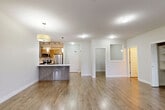 This well-appointed 2-bedroom, 2-bathroom apartment in Langley, BC offers a thoughtfully designed open-concept layout that maximizes space and functionality. The living room is bright and airy, featuring warm hardwood-style flooring, large windows, and sliding glass doors that open onto one of two private balconies overlooking verdant greenery. The modern kitchen is equipped with stainless steel appliances, warm wood-toned cabinetry, a sleek white countertop, a peninsula with pendant lighting, and track lighting overhead — ideal for both everyday cooking and entertaining. A versatile den provides additional flexible living space. Both bedrooms are generously sized, with the primary bedroom offering direct balcony access through sliding glass doors and serene views of surrounding trees. Soft carpet flooring adds comfort to the bedrooms. The two bathrooms are clean and contemporary, featuring tiled floors, a soaker tub with tiled surround, and wide vanity mirrors. Four closets provide ample storage throughout. In-suite laundry adds everyday convenience. The unit's neutral colour palette, consistent flooring, and abundant natural light create a calm, welcoming ambiance throughout this well-rounded Langley residence.