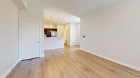 Located at 2281 East 89th St in Cleveland, OH, this well-appointed 2-bedroom, 2-bathroom home spans three floors, offering a thoughtfully designed layout with modern finishes throughout. The main living floor centers around an open-concept kitchen and living room, bathed in natural light from multiple windows. The kitchen is a standout feature, showcasing rich dark cabinetry, crisp white countertops, a peninsula with pendant lighting, and a full suite of stainless steel appliances including a refrigerator, range, microwave, and dishwasher. Light hardwood flooring flows seamlessly through the living and kitchen areas, enhancing the bright, airy atmosphere. Two staircases with striking dark treads and white risers connect the floors with clean, contemporary style. The upper floor hosts the bedrooms, both carpeted for comfort and filled with natural light. The spacious primary bedroom features a ceiling fan and ample room, while the second bedroom includes a wall-mounted AC unit and outdoor views. Two full bathrooms include tub-shower combinations with white tile surrounds and dark vanity cabinetry. Additional spaces include a laundry room, pantry, utility room, closets, and an entrance, rounding out this functional and modern home.