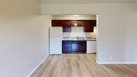 Located at 1611 Madrone Ave in West Sacramento, CA, this single-floor unit offers an efficient and well-appointed layout. Light wood-style flooring runs throughout the space, creating a clean, cohesive aesthetic that ties each room together.

The kitchen is a standout feature, equipped with rich dark wood cabinetry, granite-look countertops, a stainless steel sink, and white appliances including a full-size refrigerator and dishwasher. An open pass-through connects the kitchen to the living area, enhancing the sense of openness in the space.

The bedroom is generously sized relative to the overall footprint and is filled with natural light from a window overlooking outdoor greenery. A ceiling fan with a light fixture adds both comfort and function. The bedroom provides direct access to a dedicated closet with shelving and a hanging rod, as well as an en-suite bathroom featuring a vanity with mirror, toilet, and tub/shower combination.

Neutral wall tones throughout the unit complement the light flooring and white trim, giving the space a bright, move-in-ready feel. The thoughtful layout maximizes every square foot, making this unit a practical and comfortable home in West Sacramento.