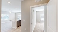 Located at 5391 W Fayetteville Rd in College Park, GA, this two-bedroom, two-bathroom residence offers a thoughtfully designed single-floor layout with modern finishes throughout. The open-concept kitchen and living area serves as the heart of the home, featuring a large granite-topped island, sleek gray cabinetry, stainless steel appliances including a refrigerator, range, microwave, and dishwasher, and light wood-look flooring that adds warmth and continuity to the space. Recessed lighting illuminates the kitchen, enhancing its clean, contemporary feel. Connecting hallways lead to two well-proportioned bedrooms, each carpeted for comfort and equipped with ceiling fans and windows fitted with blinds that allow for natural light control. The primary bedroom includes a walk-in closet outfitted with wire shelving systems, providing ample organized storage. Both bathrooms echo the home's design language with granite vanity countertops and gray cabinetry. One bathroom features a shower-tub combo and is directly accessible from the adjoining bedroom. The neutral warm-gray color palette flows seamlessly throughout, creating a cohesive and inviting ambiance. A dedicated closet and multiple hallways add to the home's practical storage and circulation solutions.
