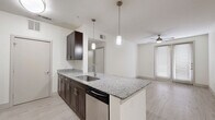 This 2-bedroom, 2-bathroom residence at 4520 Gus Thomasson Rd in Mesquite, TX offers a thoughtfully designed single-floor layout with modern finishes throughout. The open-concept living and kitchen area serves as the heart of the home, featuring light wood-look flooring, pendant lighting, and a spacious granite-topped peninsula with an undermount sink. The kitchen is equipped with stainless steel appliances, including a refrigerator, microwave, and dishwasher, complemented by rich dark espresso cabinetry that contrasts beautifully with the light granite countertops. A ceiling fan and French doors leading to a private outdoor area add both function and natural light to the living space. Both bedrooms are carpeted and bright, each equipped with ceiling fans and blinds-covered windows that invite natural light while maintaining privacy. The primary bedroom offers a generous footprint suitable for a full furniture arrangement. Both bathrooms mirror each other in design, featuring large-format tile flooring, dark espresso vanity cabinetry, granite countertops, a framed mirror, and a tiled tub-shower combination. A hallway connects the main living areas to the bedrooms and bathrooms, providing a logical and efficient flow throughout the residence.