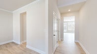 This well-appointed two-story home offers a thoughtfully designed layout across two floors. The main level features an open-concept kitchen and living area, where light hardwood-style flooring flows throughout. The kitchen is a standout highlight, equipped with granite countertops, a central island, gray cabinetry, a classic subway tile backsplash, stainless steel appliances, and an elegant chandelier overhead. The adjacent living room is bright and airy, with multiple large windows that invite generous natural light and a ceiling fan for added comfort. Hallways connect the spaces seamlessly, finished with neutral tones and clean white trim throughout. The upper level hosts four bedrooms, including a generously sized primary suite with a spacious walk-in closet featuring wire shelving for organized storage. The additional bedrooms are carpeted and well-lit with exterior-facing windows. Both bathrooms are clean and functional, with one featuring a full tub-shower combination and light wood-style flooring. A dedicated laundry room includes washer and dryer hookups, wire shelving above, and light flooring. The home's neutral color palette, consistent finishes, and well-distributed layout make it a versatile and comfortable living space.