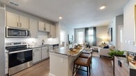 Located at 3100 Sweet Bay Avenue in Panama City, FL, this single-floor, 2-bedroom, 2-bathroom residence offers a thoughtfully designed open-concept layout. The kitchen is a standout feature, showcasing granite countertops, soft gray cabinetry with black hardware, a classic white subway tile backsplash, stainless steel appliances, and a center island with bar seating — ideal for both cooking and casual dining. The kitchen flows seamlessly into the living room, which is bathed in natural light from large windows and a glass door that opens to an outdoor area, complemented by warm hardwood-style flooring throughout.

The primary bedroom offers a comfortable, carpeted retreat with direct access to a dedicated bathroom and a walk-in closet with built-in wire shelving. The second bedroom is equally inviting, featuring plush carpeting, multiple windows for abundant natural light, and a ceiling fan. Both bathrooms are finished with granite-topped vanities and hardwood-style flooring. A dedicated laundry room houses a full-size washer and dryer. Two closets provide ample storage throughout the home. The space maintains a cohesive, modern aesthetic with neutral tones and clean architectural lines throughout.