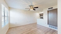 This single-floor unit offers a clean, functional layout designed for comfortable everyday living. The open living area is a welcoming space, finished with light wood-style flooring and neutral walls that create a bright, airy atmosphere. A ceiling fan with an integrated light fixture adds both comfort and practicality, while a textured ceiling provides classic character throughout. Adjacent to the living space, a pass-through counter connects seamlessly to the kitchen, which is equipped with gray cabinetry, a black range, an under-cabinet range hood, a sink, and recessed lighting — offering a compact yet efficient cooking environment. A built-in closet near the entry provides convenient storage. The bedrooms are carpeted for warmth and comfort, each featuring neutral tones and access to closet space, making them versatile and easy to personalize. The bathroom is clean and straightforward, featuring a full soaking tub with shower, a toilet, wood-style flooring, and chrome fixtures and accessories. Throughout the unit, consistent finishes and a neutral color palette create a cohesive, move-in ready environment suited to a variety of lifestyles.