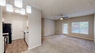 Located at 7840 Moon Rd in Columbus, Georgia, this single-story residence offers two bedrooms and two bathrooms within a well-organized and functional floor plan. The open-concept kitchen and living area form the heart of the home, where wood-look flooring, pendant lighting, and a ceiling fan create a welcoming and practical space. The kitchen features white cabinetry, light countertops, and black appliances including a range, microwave, refrigerator, and dishwasher, with ample upper and lower cabinet storage throughout. The living area is carpeted and benefits from natural light streaming through a large window and a glass door leading to an outdoor area. The primary bedroom is generously sized, carpeted, and equipped with a ceiling fan, outdoor access via a private door, and a large window with blinds. It includes a dedicated closet for ample storage. The second bedroom is also carpeted, features a ceiling fan and a window, and is well-proportioned. Both bathrooms are finished with wood-look flooring, white vanities with light countertops, white cabinetry, and mirrors. One bathroom includes a full tub/shower combination. A utility room and two closets round out the home's practical layout, making this a well-appointed and comfortable residence.