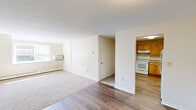 Located at 59 Mill Pond Road in Broad Brook, Connecticut, this one-bedroom, one-bathroom residence offers a practical and comfortable single-floor layout. The open living area greets you with warm hardwood-style flooring and neutral-toned walls, creating a bright and inviting atmosphere. A textured ceiling adds character throughout the main living space, which transitions seamlessly from a carpeted lounge area near the window to the wood-floor entry and kitchen corridor.

The kitchen is thoughtfully equipped with warm wood cabinetry, white appliances including a range, dishwasher, and refrigerator, and durable countertops. Its open-entry design connects easily to the main living area, supporting a functional flow throughout the home.

The bedroom offers a comfortable, carpeted retreat with a window unit for climate control, baseboard heating, and a natural light source through a well-positioned window. Ample storage is provided by three closets, including a generously sized walk-in style closet with full-length shelving and hanging rods.

The bathroom features clean, white fixtures with a mirrored medicine cabinet, maintaining the home's consistent neutral palette. Throughout, baseboard heating ensures year-round comfort, and the well-organized layout maximizes every inch of the available space.